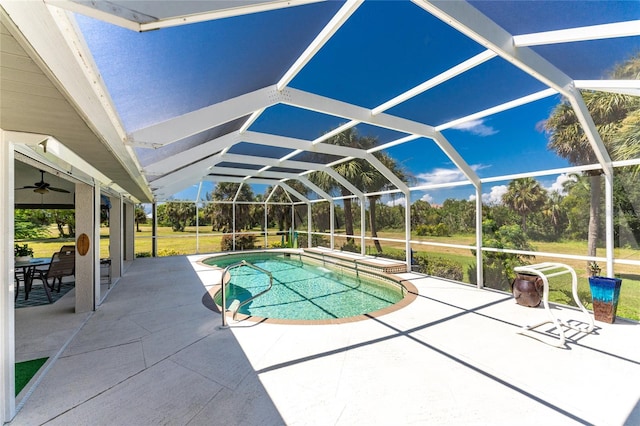 view of swimming pool with glass enclosure and a patio