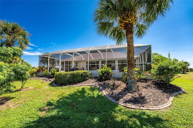 rear view of property with a yard and a lanai