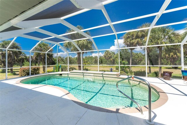 16407 San Edmundo Rd, Punta Gorda, FL 33955 - outdoor pool featuring a patio area, glass enclosure, and view of wooded area