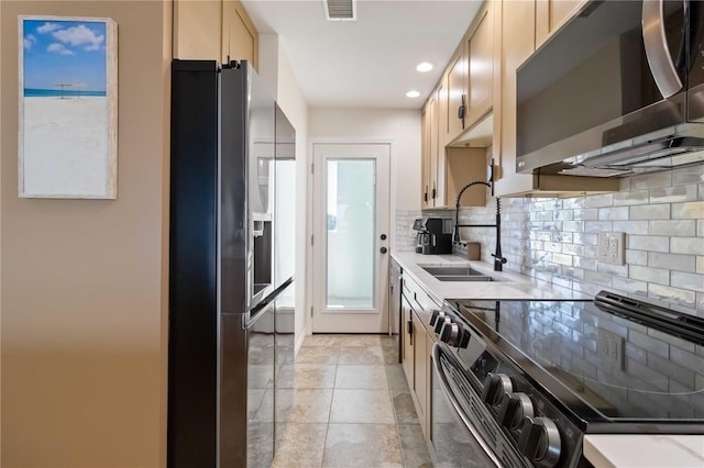 kitchen with appliances with stainless steel finishes, tasteful backsplash, light brown cabinetry, sink, and plenty of natural light