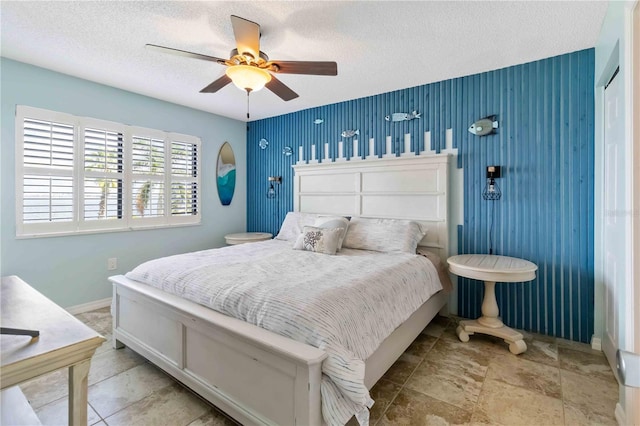 bedroom with ceiling fan and a textured ceiling