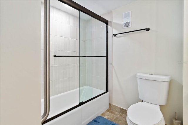 bathroom featuring toilet and combined bath / shower with glass door