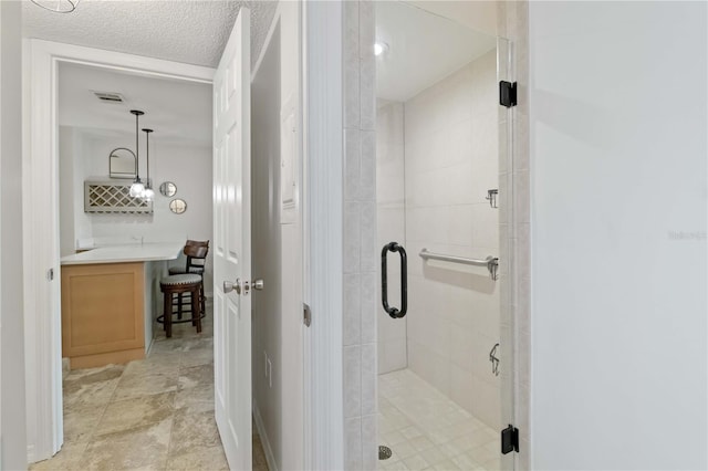 bathroom featuring walk in shower and a textured ceiling