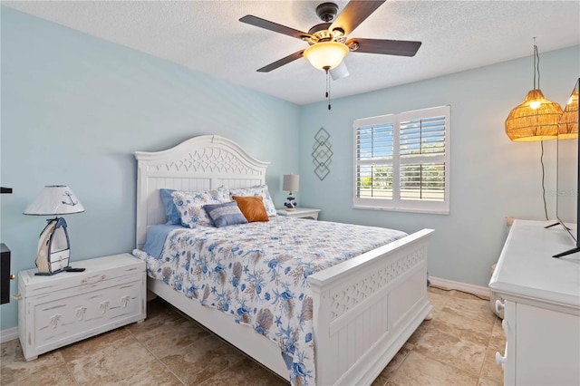 bedroom featuring ceiling fan and a textured ceiling