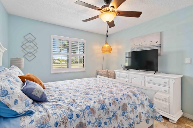 bedroom featuring ceiling fan and a textured ceiling