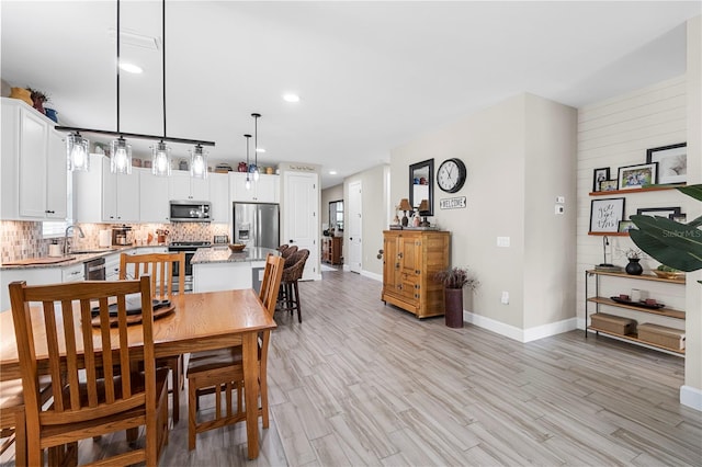 dining area featuring light wood-type flooring and sink