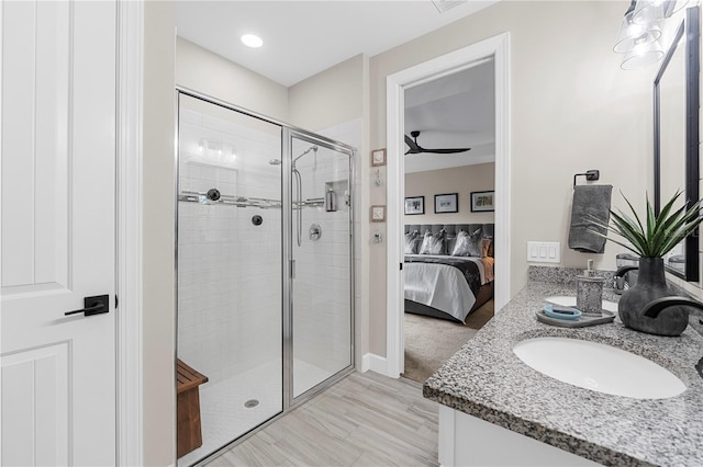 bathroom featuring a shower with door, ceiling fan, vanity, and hardwood / wood-style flooring