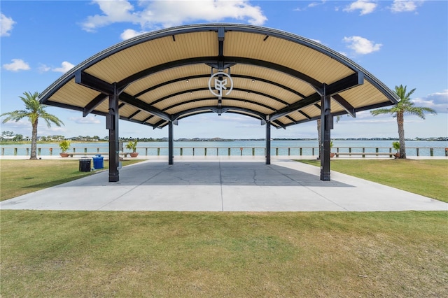 view of parking / parking lot with a lawn and a water view