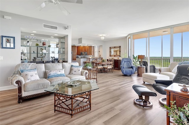 living room with light hardwood / wood-style flooring, floor to ceiling windows, and ceiling fan