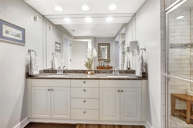 bathroom with vanity and a shower with door