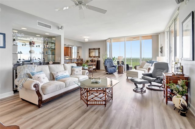 living room featuring light hardwood / wood-style flooring and ceiling fan