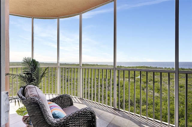 sunroom featuring a water view and plenty of natural light