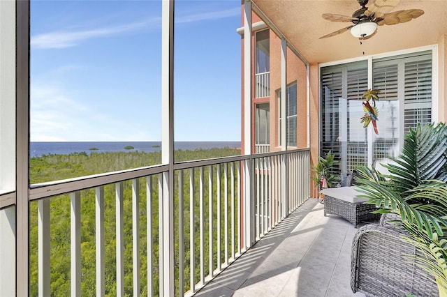 sunroom / solarium featuring a water view, ceiling fan, and a wealth of natural light