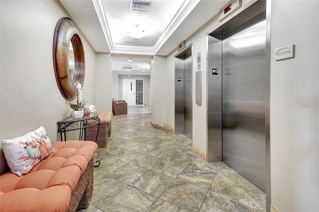 hallway featuring a raised ceiling, crown molding, and elevator