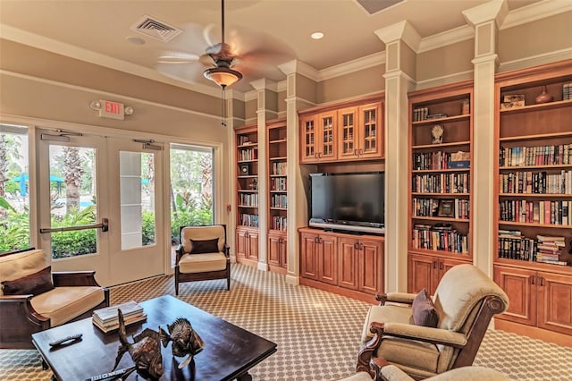 living room featuring ornamental molding, decorative columns, ceiling fan, and carpet floors