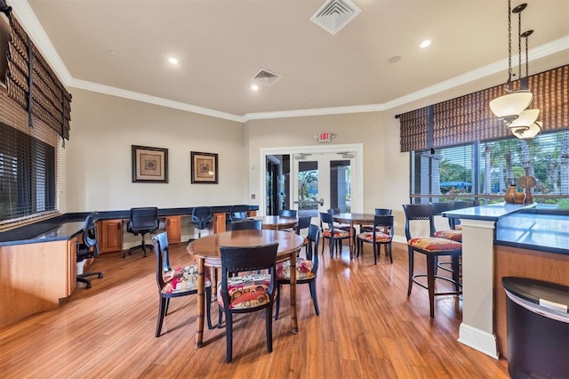 dining space featuring light hardwood / wood-style flooring, french doors, and crown molding