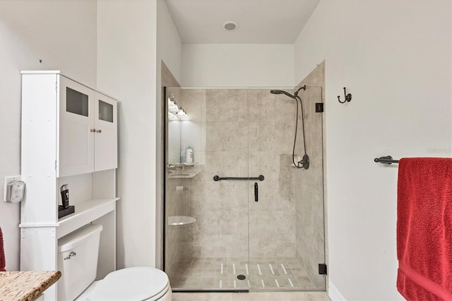 bathroom featuring tile patterned flooring, a shower with door, and toilet