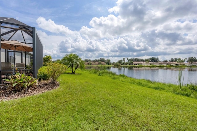 view of yard featuring a water view and glass enclosure