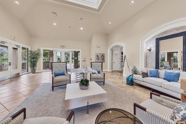 living room featuring a healthy amount of sunlight, high vaulted ceiling, and french doors