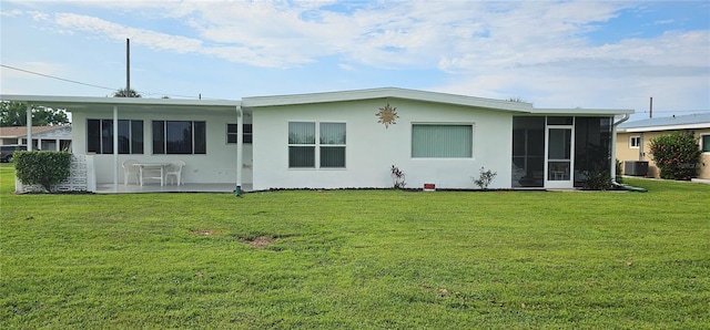 rear view of house with central AC unit and a yard