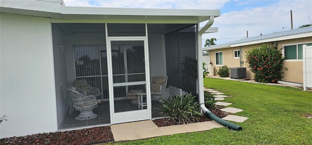 entrance to property with a yard and central AC unit