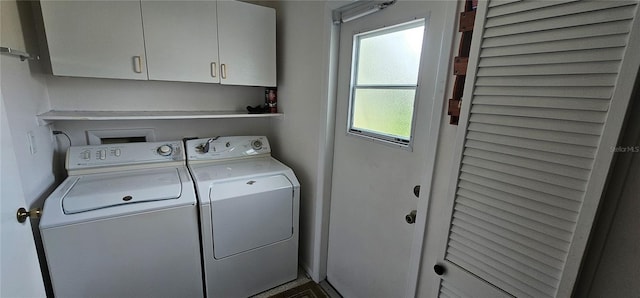 clothes washing area with cabinets and separate washer and dryer