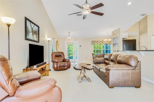 living room featuring light colored carpet, ceiling fan with notable chandelier, and vaulted ceiling