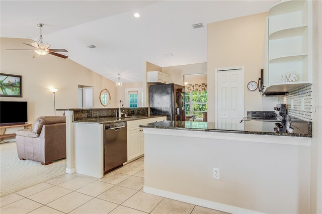 kitchen with dark stone counters, vaulted ceiling, ceiling fan, and stainless steel dishwasher