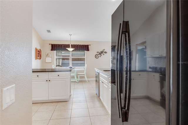 kitchen featuring dishwasher, black fridge, white cabinets, decorative light fixtures, and light tile patterned floors