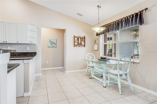 tiled dining space with vaulted ceiling