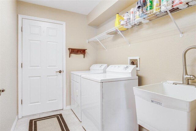 laundry room featuring sink, light tile patterned flooring, and washing machine and dryer