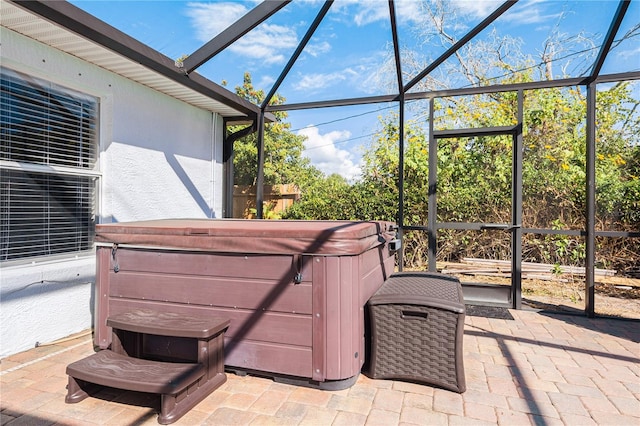 view of patio featuring glass enclosure and a hot tub