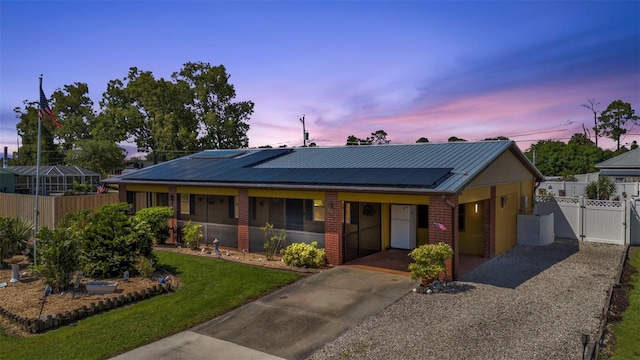 view of front of house with a yard and solar panels