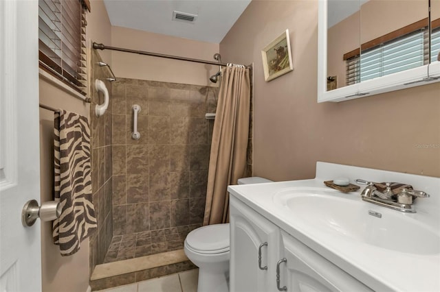 bathroom featuring vanity, toilet, tile patterned floors, and walk in shower