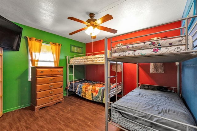 bedroom featuring dark wood-type flooring, ceiling fan, and a textured ceiling