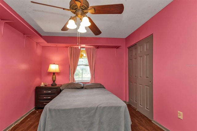 bedroom featuring dark wood-type flooring, ceiling fan, and a closet