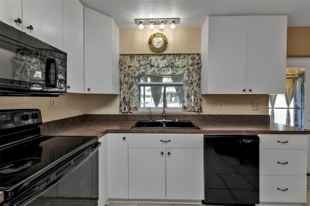 kitchen with a healthy amount of sunlight, black appliances, and white cabinets