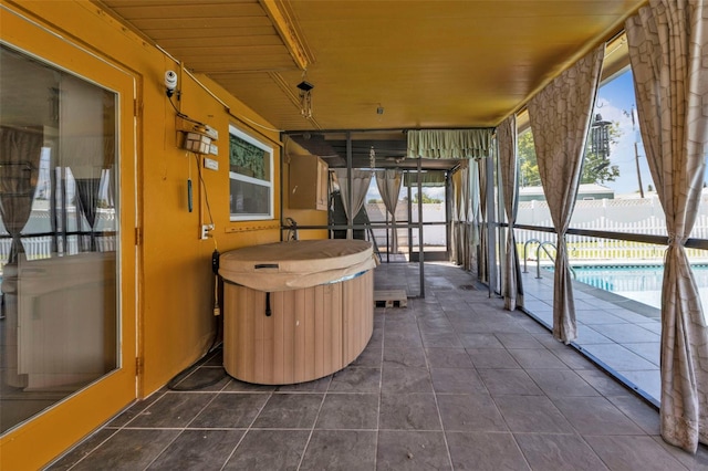 unfurnished sunroom featuring wood ceiling, a hot tub, and plenty of natural light