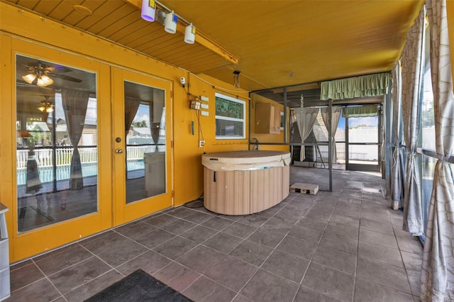 unfurnished sunroom with a hot tub, wood ceiling, and ceiling fan