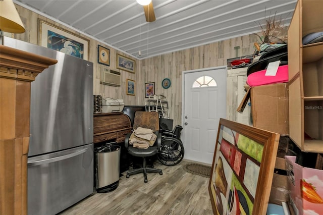 interior space with hardwood / wood-style flooring, an AC wall unit, wooden walls, and ceiling fan