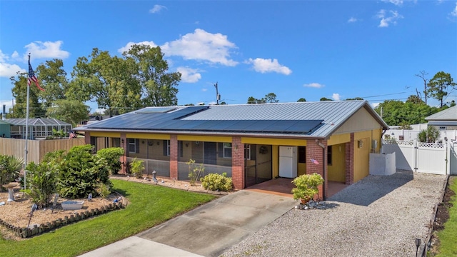 single story home with solar panels and a front yard