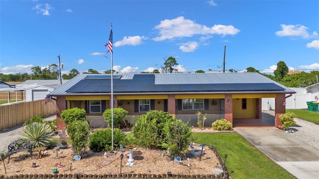 view of front facade featuring covered porch, a carport, and solar panels