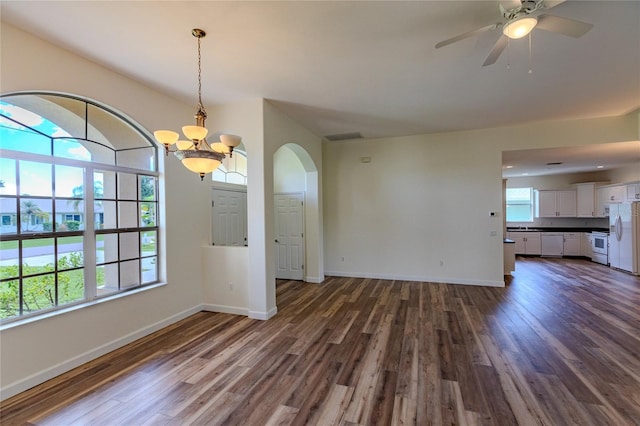 interior space featuring ceiling fan with notable chandelier and dark wood-type flooring