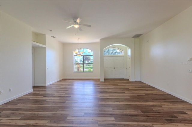 entrance foyer with ceiling fan with notable chandelier and dark hardwood / wood-style flooring