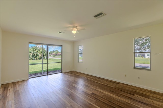 empty room with ceiling fan and dark hardwood / wood-style flooring