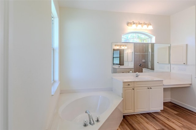 bathroom with wood-type flooring, vanity, and shower with separate bathtub