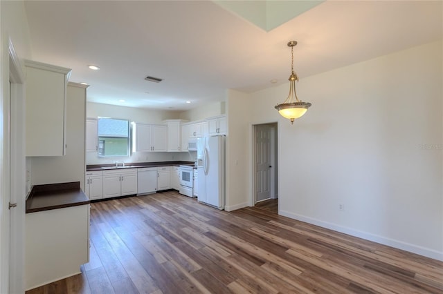 kitchen with wood-type flooring, white appliances, white cabinetry, and decorative light fixtures