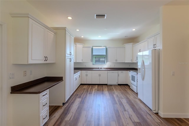 kitchen with light wood-type flooring, white appliances, sink, and white cabinets