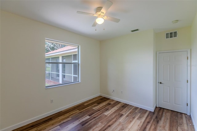 unfurnished room with ceiling fan and hardwood / wood-style flooring