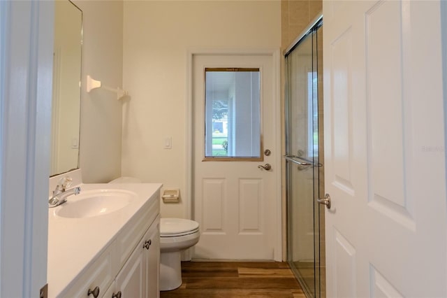 bathroom featuring an enclosed shower, hardwood / wood-style flooring, vanity, and toilet